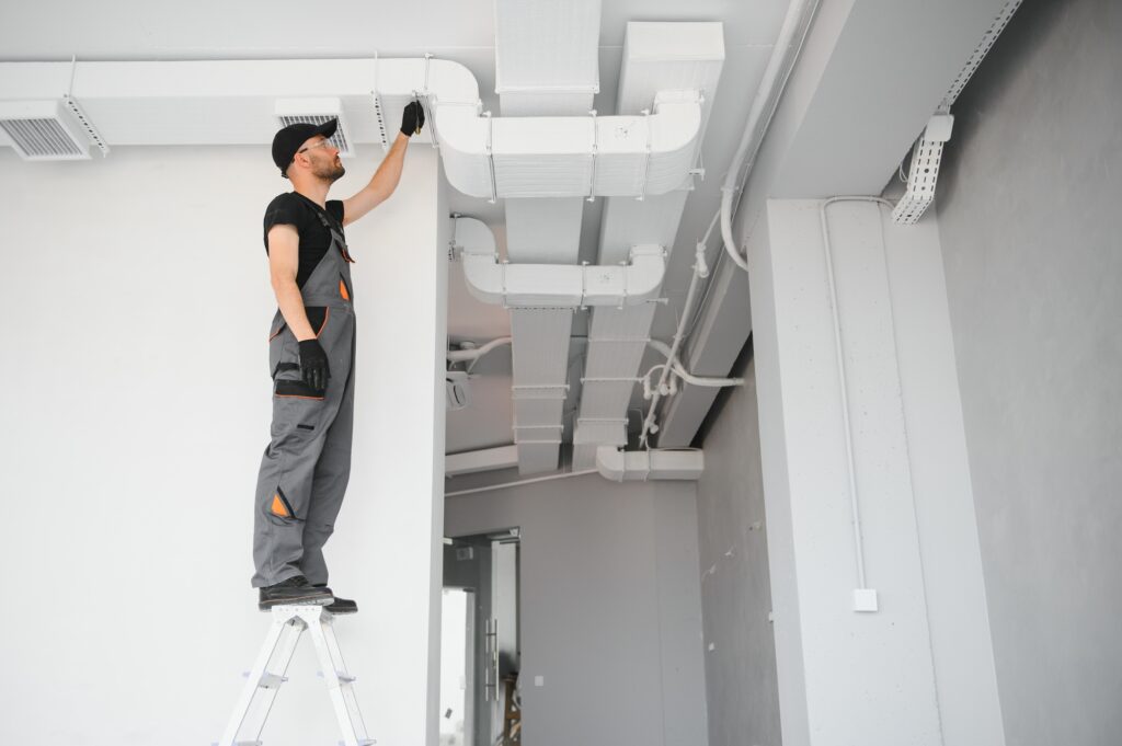 hvac services, worker install ducted pipe system for ventilation and air conditioning in house